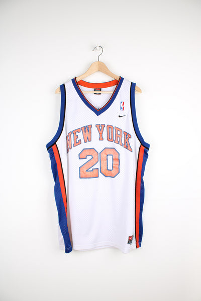 Vintage New York Knicks NBA Nike Jersey in the white, blue and orange team colourway, Allan Houston number 20 jersey, v neck and has the logos and numbers embroidered onto the front and back.