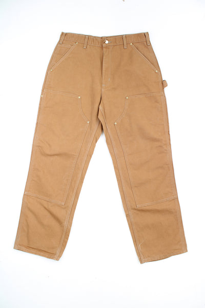 Carhartt double knee carpenter jeans in tan with multiple pockets and signature logo on the back pocket