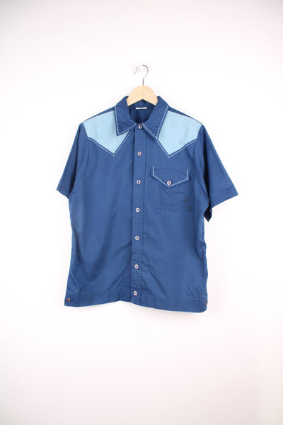 Vintage 70's Bowling Shirt in a blue colourway with western style cross stitching, button up with a dagger collar, has a chest pocket and also has 'Bowlerama, Idaho' graphic printed on the back.