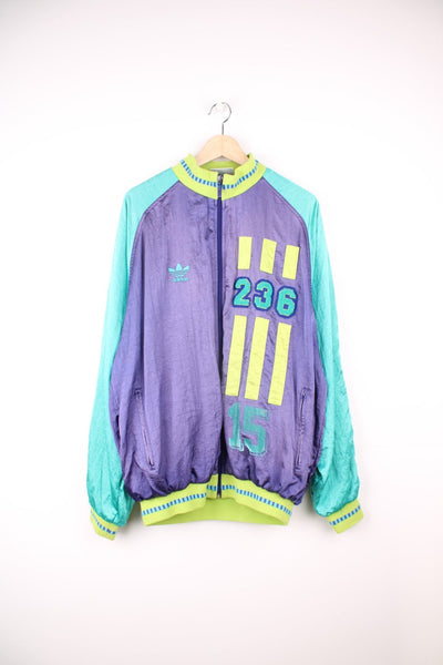 Vintage 80s Adidas tracksuit top in green and purple. Features embroidered logo on the chest, and embroidered 236 badge.