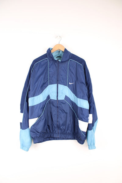 Vintage 90s Nike tracksuit top with blue and white panelling details and embroidered logo on the front and back.