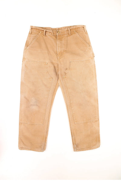 Vintage Carhartt Double Knee Trousers in a tan colourway, multiple pockets and has the logo embroidered on the back.